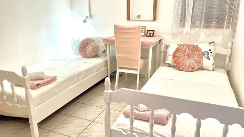 a bedroom with two beds and a table and a chair at Lovely apartments on the private Beach - island Korčula in Prizba