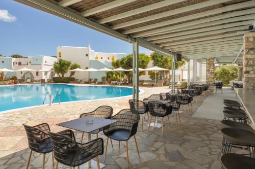 een patio met tafels en stoelen naast een zwembad bij Asteras Paradise in Naousa
