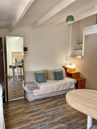 un salon avec un canapé et un miroir dans l'établissement Le Marcel, studio terrasse cœur de ville, à La Rochelle