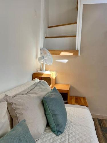 - une chambre avec un lit doté d'oreillers et un escalier dans l'établissement Le Marcel, studio terrasse cœur de ville, à La Rochelle