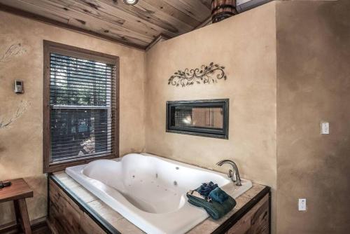 ein großes Bad mit einer Badewanne und einem Fenster in der Unterkunft Redwood in the Historic Upper Canyon in Ruidoso