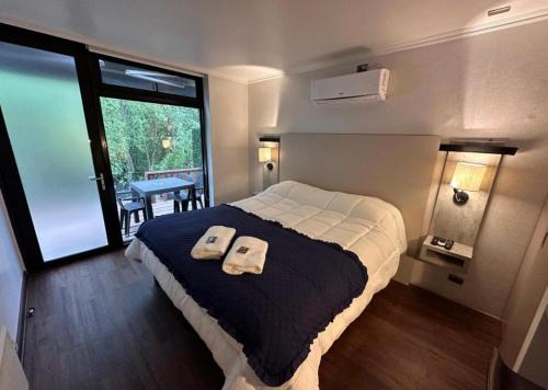 a bedroom with a bed with two towels on it at Cabañas Borde Río Jacussi in Concepción