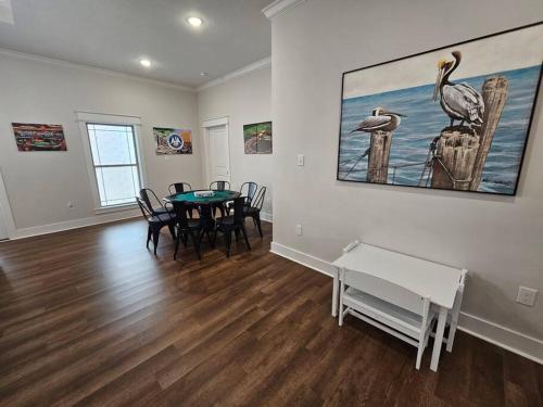查爾斯湖的住宿－Louisiana 5BR Luxury Pool Retreat，一间设有桌子和墙上绘画的用餐室