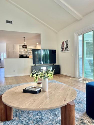 a living room with a table and a tv at Rose Garden Home, Entire 4bdr 2bth House with Offices, Thousand Oaks in Thousand Oaks