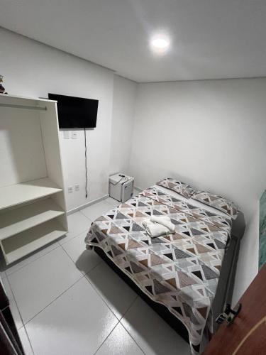 a bedroom with a bed and a flat screen tv at Suite Em Maragogi (pousada) in Maragogi