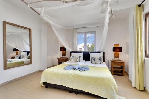 a bedroom with a large bed with a large mirror at Chachacha Ocean View Apartment on the Sea in Kralendijk