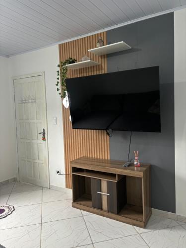 salon z telewizorem z płaskim ekranem na ścianie w obiekcie Residência Aguiar w mieście Guaratuba
