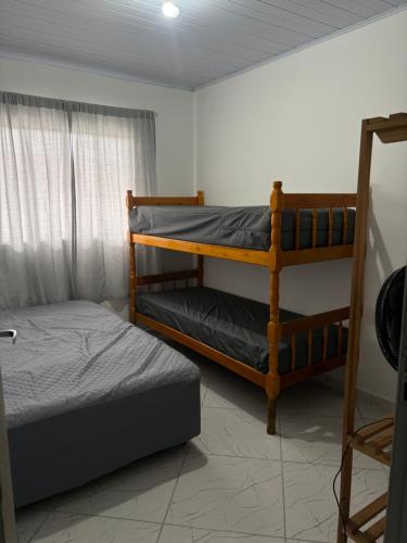 sypialnia z 2 łóżkami piętrowymi i oknem w obiekcie Residência Aguiar w mieście Guaratuba