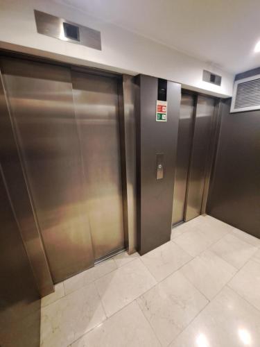 una fila di porte di un ascensore metallico in un edificio di Fabolous Marinho Apartment a Porto