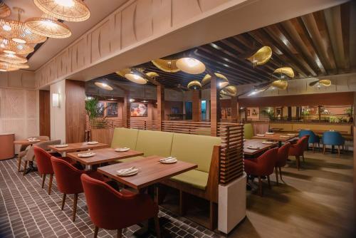 a dining room with wooden tables and chairs at Park Inn by Radisson, Riyadh in Riyadh