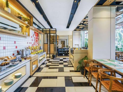 a restaurant with a tiled floor and tables and chairs at ibis Jakarta Raden Saleh in Jakarta