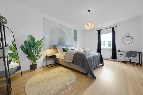 OLIVE Apartments - 86m2 - Kingsize - Free Parking في هانوفر: غرفة نوم مع سرير وزرع الفخار