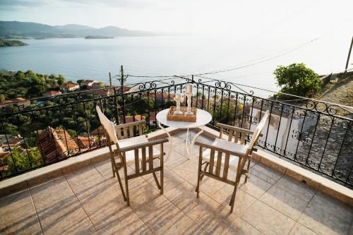 a balcony with a table and chairs and a view of the water at The Traditional House of Molivos in Mithymna