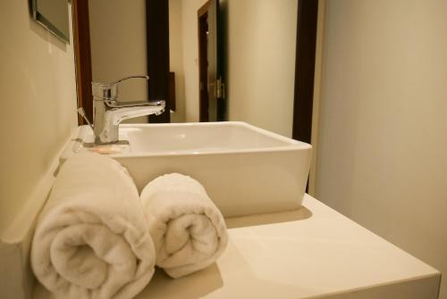 Baño con toallas en una encimera junto a un lavabo en Ceibo Real, en Portoviejo