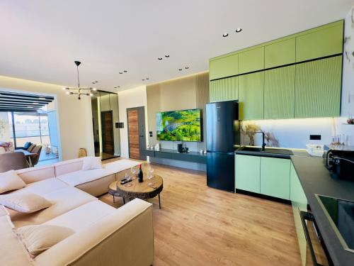 a living room with a couch and a kitchen at SEA VIEW LUXURY PENTHOUSE in Vlorë