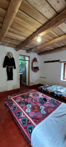 a bedroom with two beds and a rug on the floor at Albergue Las Abejitas in Chancos