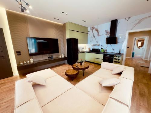 a living room with a white couch and a tv at SEA VIEW LUXURY PENTHOUSE in Vlorë
