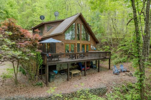 a cabin in the woods with a deck and chairs at Lakefront Cabin Bordering Nat Park with Hot Tub! cabin in Turtletown