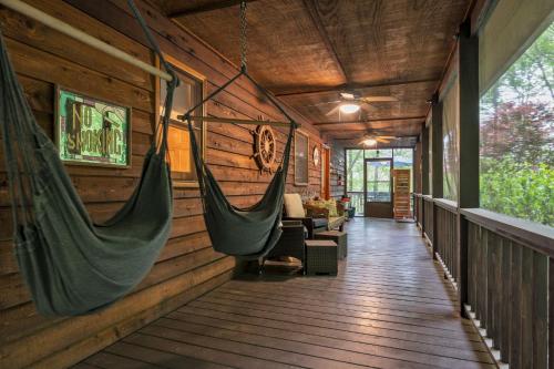 eine Veranda mit 2 Hängematten in einem Blockhaus in der Unterkunft Lakefront Cabin Bordering Nat Park with Hot Tub! cabin in Turtletown