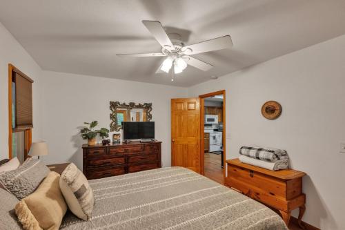 a bedroom with a bed and a ceiling fan at Lakefront Cabin Bordering Nat Park with Hot Tub! cabin in Turtletown