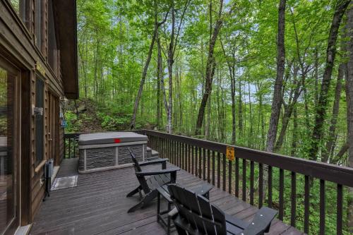 a deck with a grill and two chairs on it at Lakefront Cabin Bordering Nat Park with Hot Tub! cabin in Turtletown