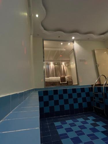 a bathroom with a mirror and a checkered floor at شاليهات ليالينا in Muhayil