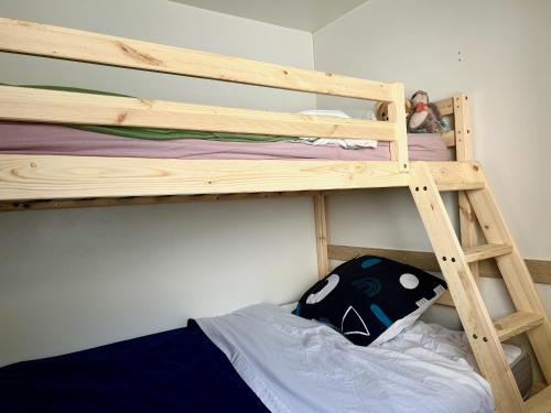 - un lit superposé en bois avec un oreiller sur la couchette inférieure dans l'établissement Tribord Dix Neuf, au Grau-du-Roi