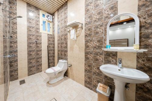 a bathroom with a sink and a toilet and a mirror at Masharef Abha Suites in Abha