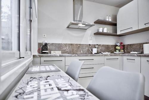 a kitchen with white cabinets and a table and chairs at AnGio City House in Análipsis