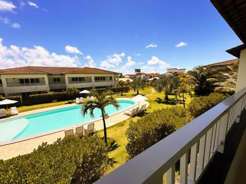 vistas a la piscina desde el balcón de un complejo en Apartamento amplo de frente para o mar em Resort, en Entre Rios