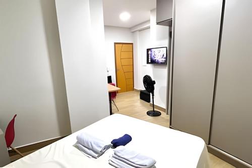 a hospital room with a bed and a television at Portofino Apart Hotel Praça do Mercado in Divinópolis