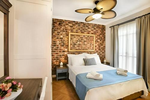 a bedroom with a bed and a brick wall at Petite Boutique Hotel in Ildır
