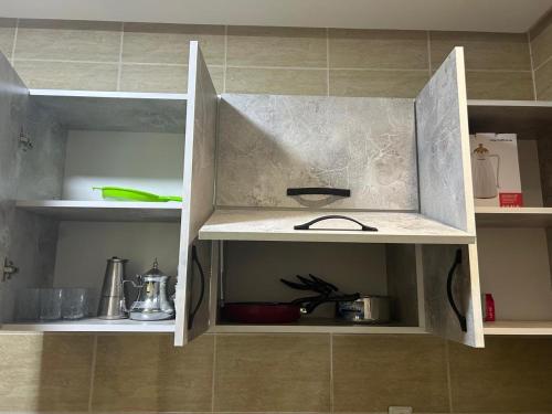 a kitchen with an open cabinet with a sink at Appart Flora in Tangier