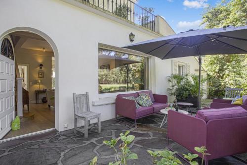 een patio met paarse meubels en een parasol bij La Maison du Golf - Welkeys in Soorts-Hossegor