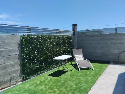 een tuin met een tafel en een stoel op het gras bij Lugar tranquilo in Colonia del Sacramento