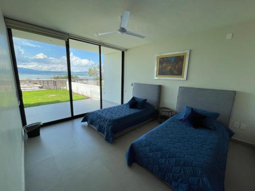 a bedroom with two beds and a large window at Monte San Andres Residencial in San Juan Cosalá