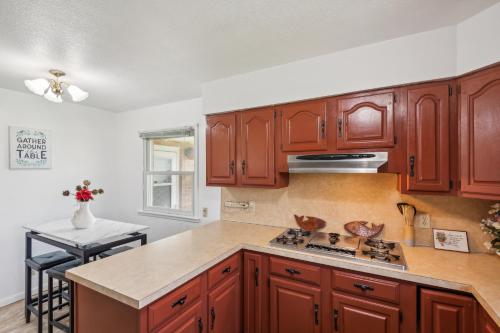 a kitchen with wooden cabinets and a stove top oven at Elkhart Haven- Cozy Family Retreat home in Elkhart