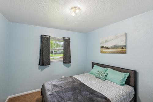 a bedroom with a bed and two windows at Elkhart Haven- Cozy Family Retreat home in Elkhart