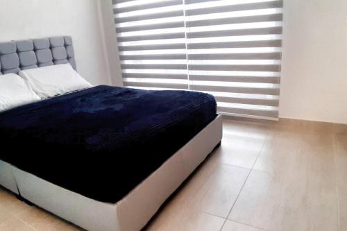 1 dormitorio con 1 cama con manta azul en Bellísima casa de descanso, piscinas increíbles RICAURTE, en Ricaurte