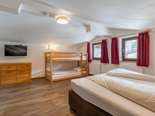 een slaapkamer met 2 bedden en een stapelbed bij Wald XXL in Fieberbrunn