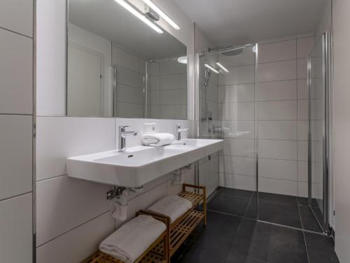 Baño blanco con lavabo y espejo en Wald TOP 1, en Fieberbrunn