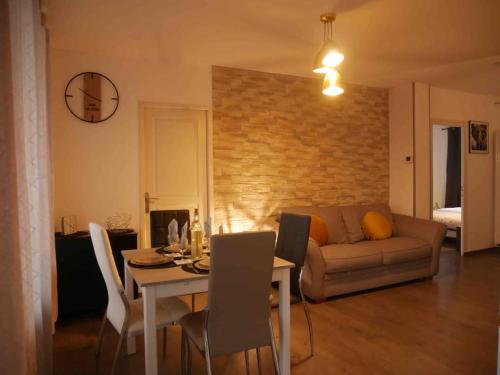 un salon avec une table et un canapé dans l'établissement Le grand arc, proche centre ville, à Albertville