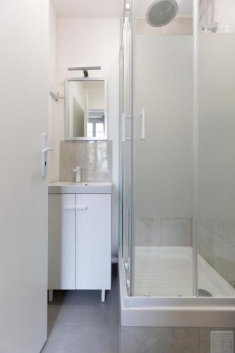 une salle de bain avec douche et lavabo dans l'établissement Appartement 3 pièces - Proche RER et centre ville, à Corbeil-Essonnes
