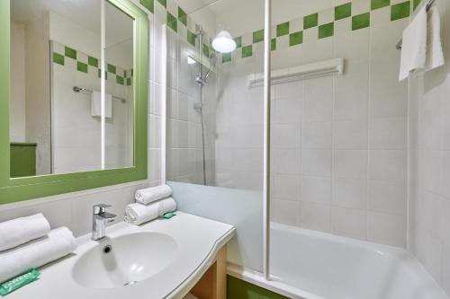 une salle de bain blanche avec un lavabo et une douche dans l'établissement Citea Deauville - Tourisme & Vacances mer, à Deauville