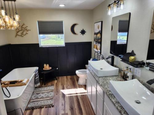 uma casa de banho com 2 lavatórios, uma banheira e um WC. em Lakeside Luxury at Duck Creek on Grand Lake, Oklahoma em Afton