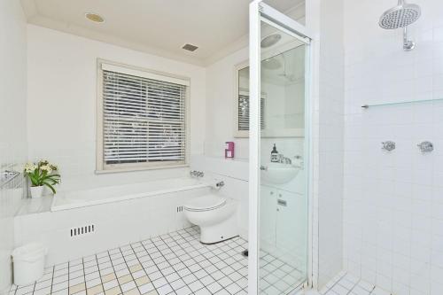 bagno bianco con servizi igienici e doccia di Villa 3br Chianti Villa located within Cypress Lakes Resort a Pokolbin