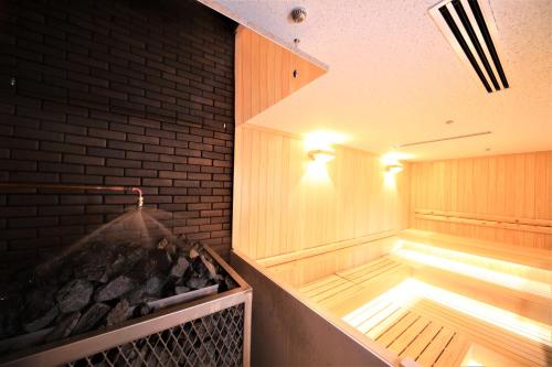 a sauna with a grill and a brick wall at -SPA RESORT- Nagoya Kasadera Hotel in Nagoya