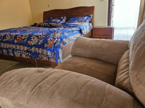 sala de estar con cama y sofá en Résidence Élisabeth en Fondjomékwet