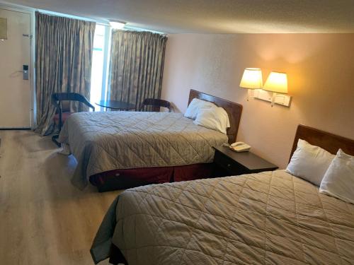 a hotel room with two beds and a table with a phone at Tollway Inn Beloit in South Beloit