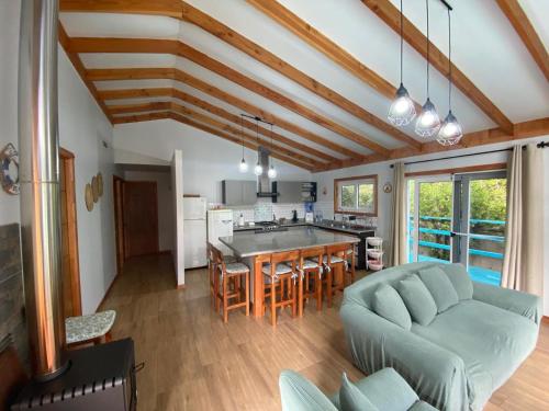 eine Küche und ein Wohnzimmer mit einem Sofa und einem Tisch in der Unterkunft Casa veraneo Consistorial El Tabo Chile in El Tabo